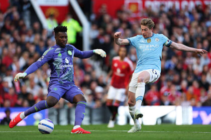 MANCHESTER, ENGLAND - APRIL 06: Andre Onana of Manchester United clears the ball under pressure from Kevin De Bruyne of Manchester City during the Premier League match between Manchester United FC and Manchester City FC at Old Trafford on April 06, 2025 in Manchester, England. (Photo by Michael Steele/Getty Images)